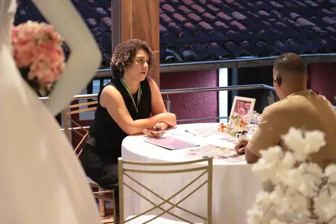 Atendente conversando com visitantes na mesa do estande