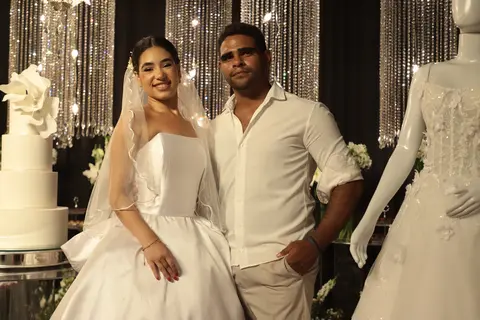 Casal de noivos sorrindo em estande de vestidos