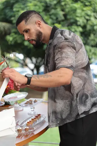 Confeiteiro servindo doces em bandeja para visitantes