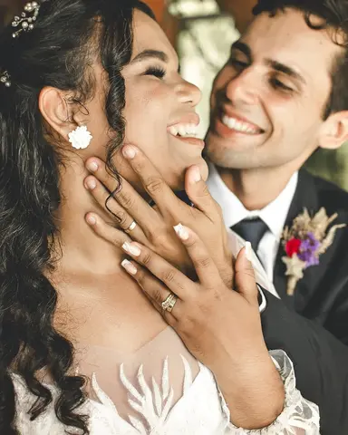 Casal rindo mostrando a aliança