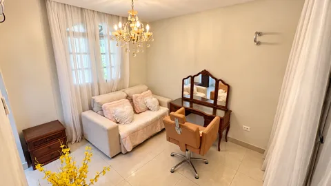 Sala de produção com sofá, penteadeira com espelho, cadeira e lustre de cristal