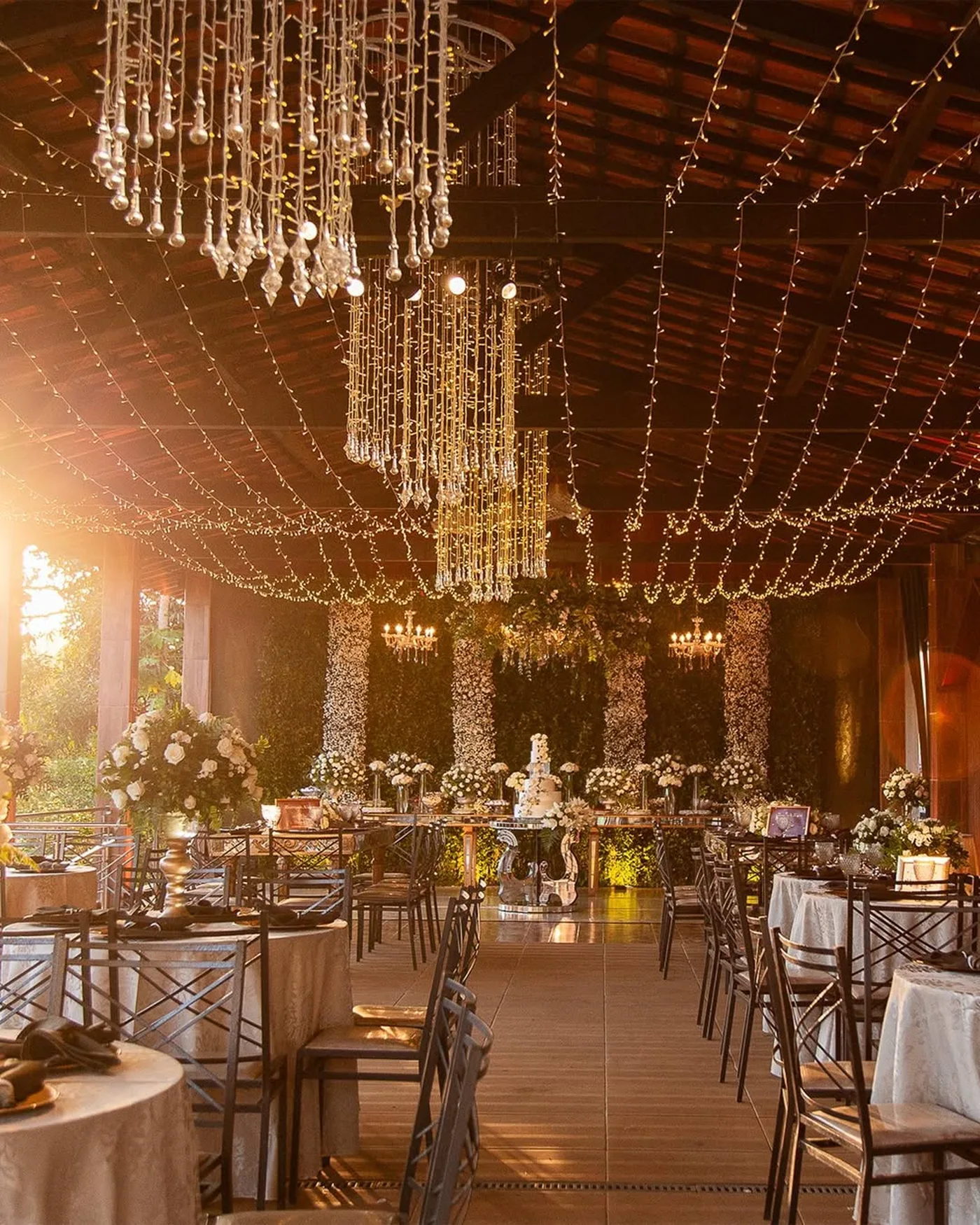 Salão decorado com cortina de luzes e lustres