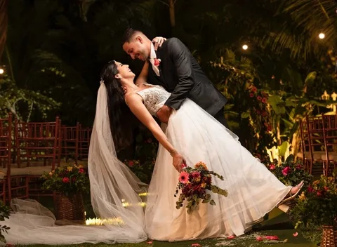 Casal dançando no jardim à noite