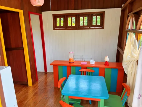 Interior da casinha infantil com balcão e mesinha coloridos