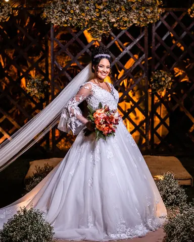 Noiva de véu longo diante do portal decorado