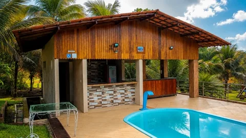 Quiosque de madeira com piscina em dia de sol